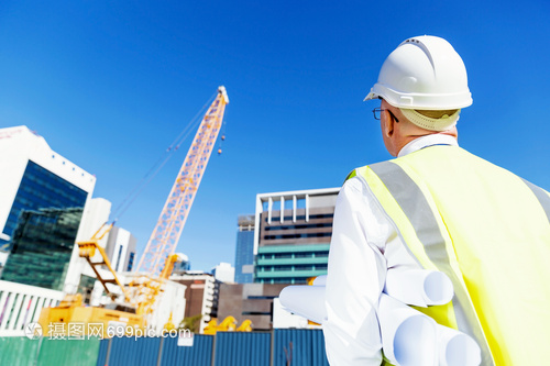 建筑工地的工程師建設(shè)者工程師建筑工人施工場景穿著帶藍(lán)圖的安全背心